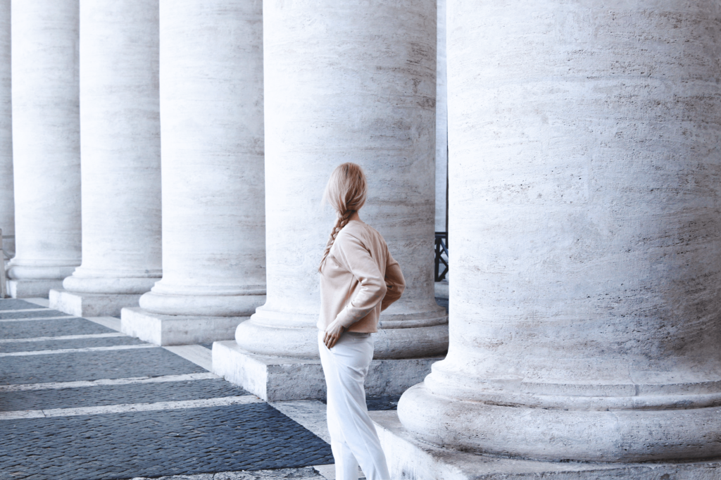 Photo of Woman Standing Beside Concrete Pillar