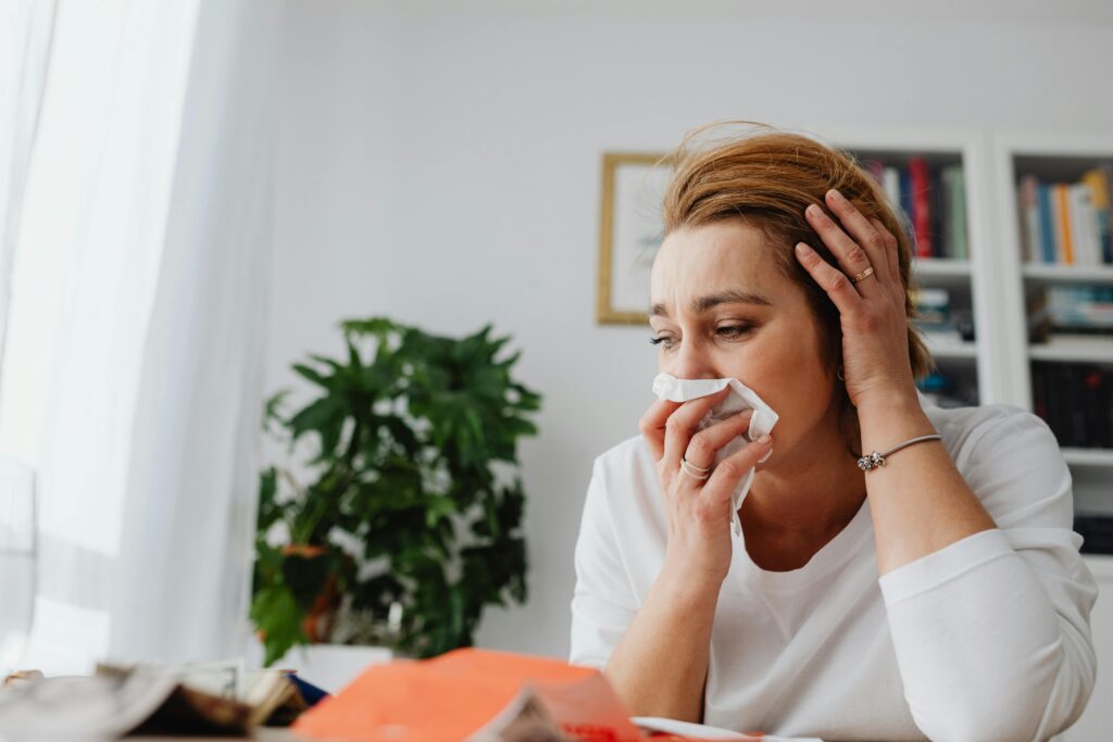 A women blowing her nose.