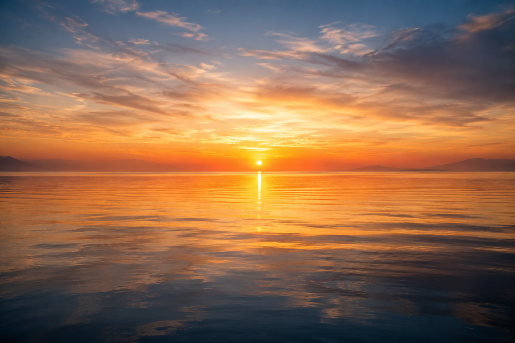 Sunrise over calm ocean water symbolizing personal growth, neuroplasticity, transformation, and new possibilities.